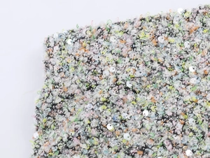 Vue macro du tissu en tweed multicolore avec des ornements de paillettes rondes brillantes