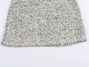 Gros plan sur le tissu en tweed à paillettes avec des fibres roses et vertes