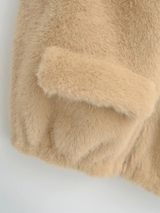 Close-up of a camel faux fur vest pocket showing premium soft texture and sewing details