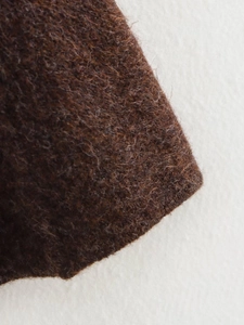 Gros plan sur la texture en laine pelucheuse marron d'un ensemble en tricot mode