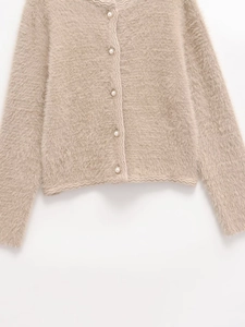 Detail of faux mink fur cardigan with pearl buttons and scalloped edge knitting
