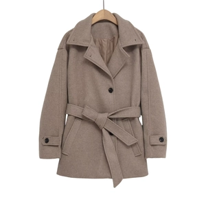 Détail d'un manteau élégant en imitation laine avec col à revers et ceinture pour femme