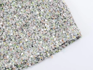 Gros plan sur un tissu en tweed multicolore avec des paillettes argentées brillantes