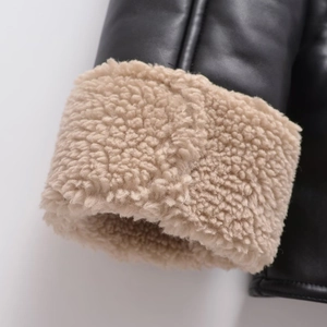 Close-up of stylish PU leather jacket with thick beige faux shearling lining and cuffs