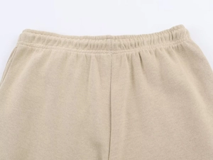 Detail view of beige knitted sweatpants waist with elastic band and premium stitching