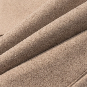 Close-up of premium camel wool fabric with detailed texture and neat stitching on coat