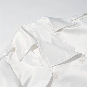 Detailed macro view of white satin trench coat collar with lapels and shoulder epaulettes