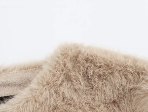 Vue macro de la texture de fausse fourrure douce sur une veste d'automne beige chic