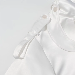 Macro shot of white satin trench coat details featuring shoulder epaulettes and buttons
