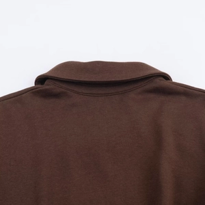 Detailed view of the dark brown polo collar and high-quality knitted fabric texture
