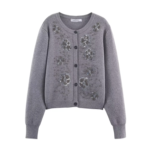 Close-up of grey knit cardigan featuring intricate floral beadwork and sequin embellishments