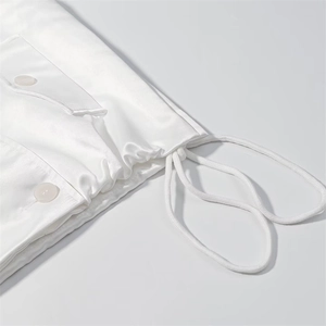 Detail of white satin trench coat with smooth texture, round buttons and woven drawstring