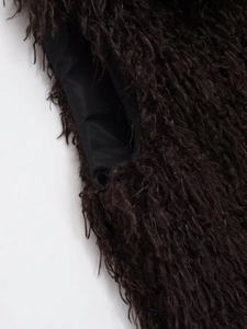 Detail shot of the dark brown faux fur texture and smooth black inner lining fabric
