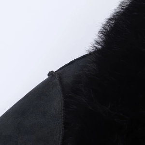 Detailed close-up showing the premium black suede and faux fur stitching of this long coat