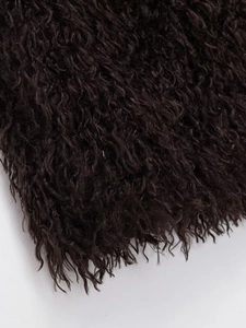 Macro shot of the curly dark brown faux fur texture on this stylish winter vest