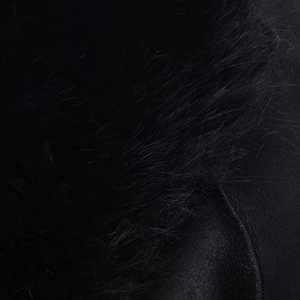 Close-up detail of luxury black faux fur texture and leather lining on this winter coat