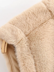 Gros plan sur la texture douce en fausse fourrure d'un gilet beige sans manches femme