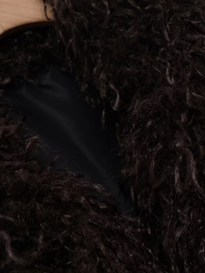 Detailed macro view of plush faux fur texture and smooth inner lining of the vest jacket