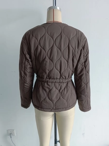 Macro detail of the brown quilted jacket featuring a stylish elastic drawstring waist design