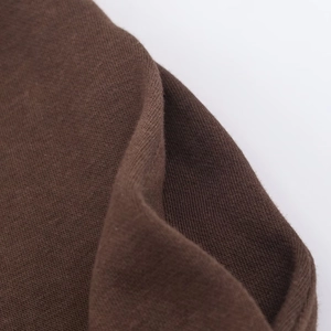Vue macro de la texture épaisse du tricot marron foncé utilisé pour les survêtements