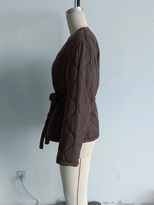 Detailed side view of dark brown quilted jacket featuring a stylish diamond stitch and waist drawstring