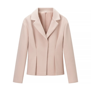 Détail d'un blazer rose clair montrant le revers, la texture et l'étiquette de taille