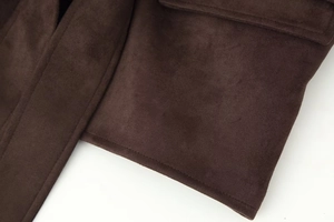 Macro shot of dark brown faux suede fabric detailing the fine stitching and texture