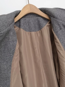 Détail de manteau en laine gris foncé avec doublure marron et finitions soignées