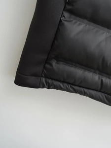 Detailaufnahme einer schwarzen Steppweste mit Stoffmix und hochwertigen Nähten