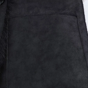 Detail of black faux fur lining and matte suede stitching on long winter coat
