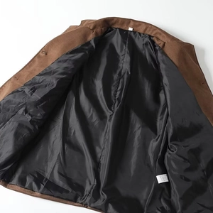 Close-up detail of brown suede jacket showing the inner lining and white care label