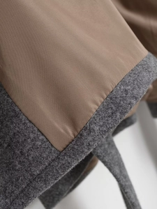 Détail du tissu en laine mélangée gris foncé avec doublure marron et couture précise