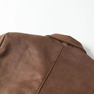 Close-up of brown suede blazer collar and stitching detail with soft texture finish