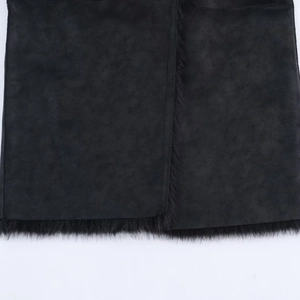 Detail of matte black faux fur trim and suede fabric stitching on the coat hemline