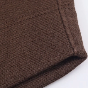 Gros plan détaillé du tissu en maille marron foncé avec finitions à double couture