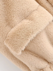 Détail macro de fausse fourrure abricot douce montrant la texture luxueuse de la veste