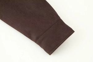 Detail of dark brown faux suede cuff with neat stitching and plush fabric texture