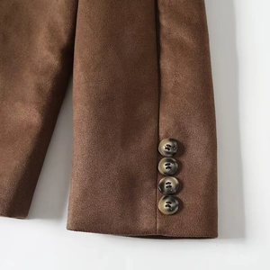 Macro detail of faux suede jacket sleeve featuring four dark tortoiseshell buttons