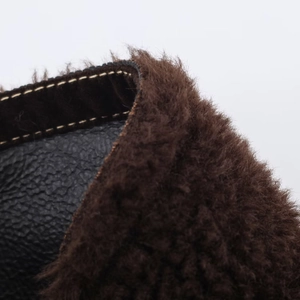 Detailed view of brown faux fur lining with black lychee leather and double stitching