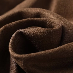 Detailed macro view of dark brown suede-textured fabric with soft brushed finish