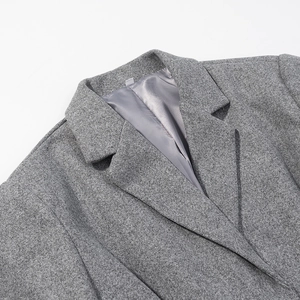 Gros plan détaillé du revers du manteau en laine grise avec texture et doublure satin