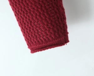 Dettaglio del cardigan bordeaux in maglia traforata con texture morbida e rifinita