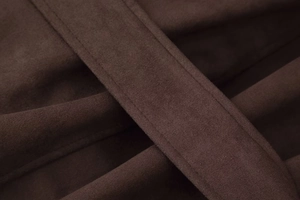Detail of dark brown faux suede fabric with precise double-stitching and soft texture