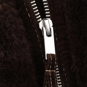 Close-up of a silver metal zipper on a dark brown faux fur jacket with soft texture
