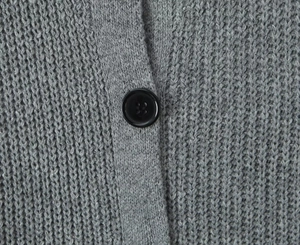 Vista detallada de la textura de punto grueso gris con un botón negro redondo