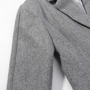 Vue détaillée du tissu en laine grise et des coutures de haute qualité de la veste