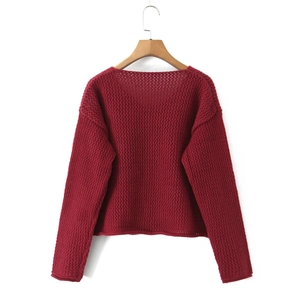 Dettaglio della maglia traforata rosso vino e dei bottoni su questo cardigan corto