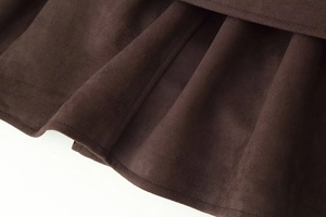 Detailed macro view of dark brown suede fabric texture with clean stitching and soft folds