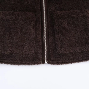 Detail of dark brown faux fur vest with silver metal zipper and two large patch pockets