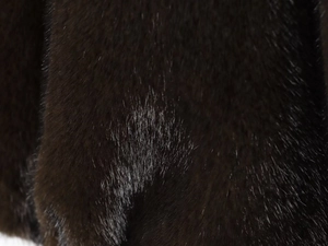 Macro shot of dark brown faux fur texture showing soft plush and glossy fibers